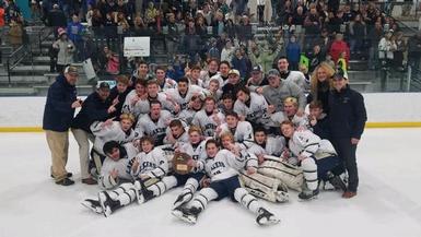 The boys ice hockey team poses for a photo after winning their regional championship.