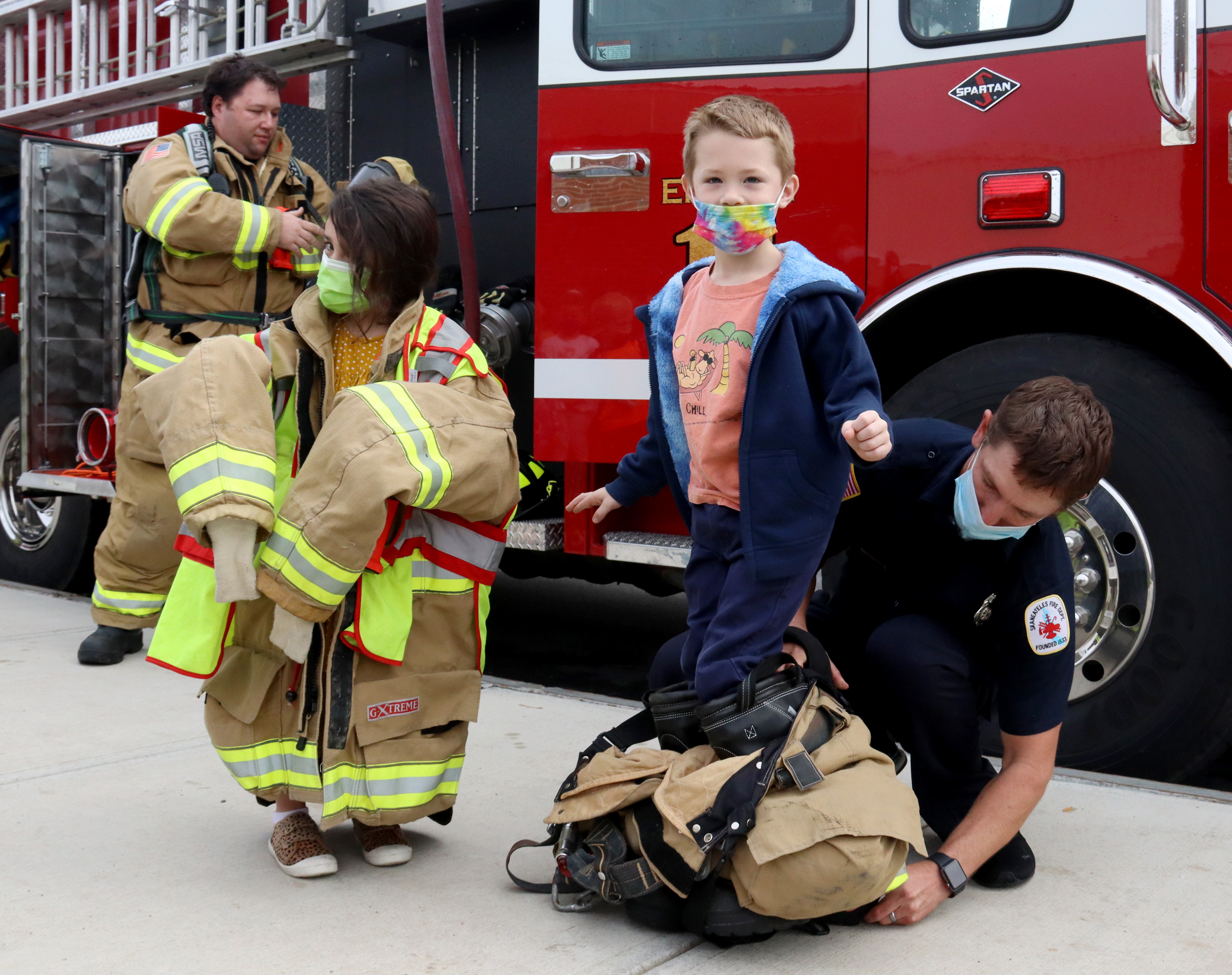 Students try on firefighter equipment