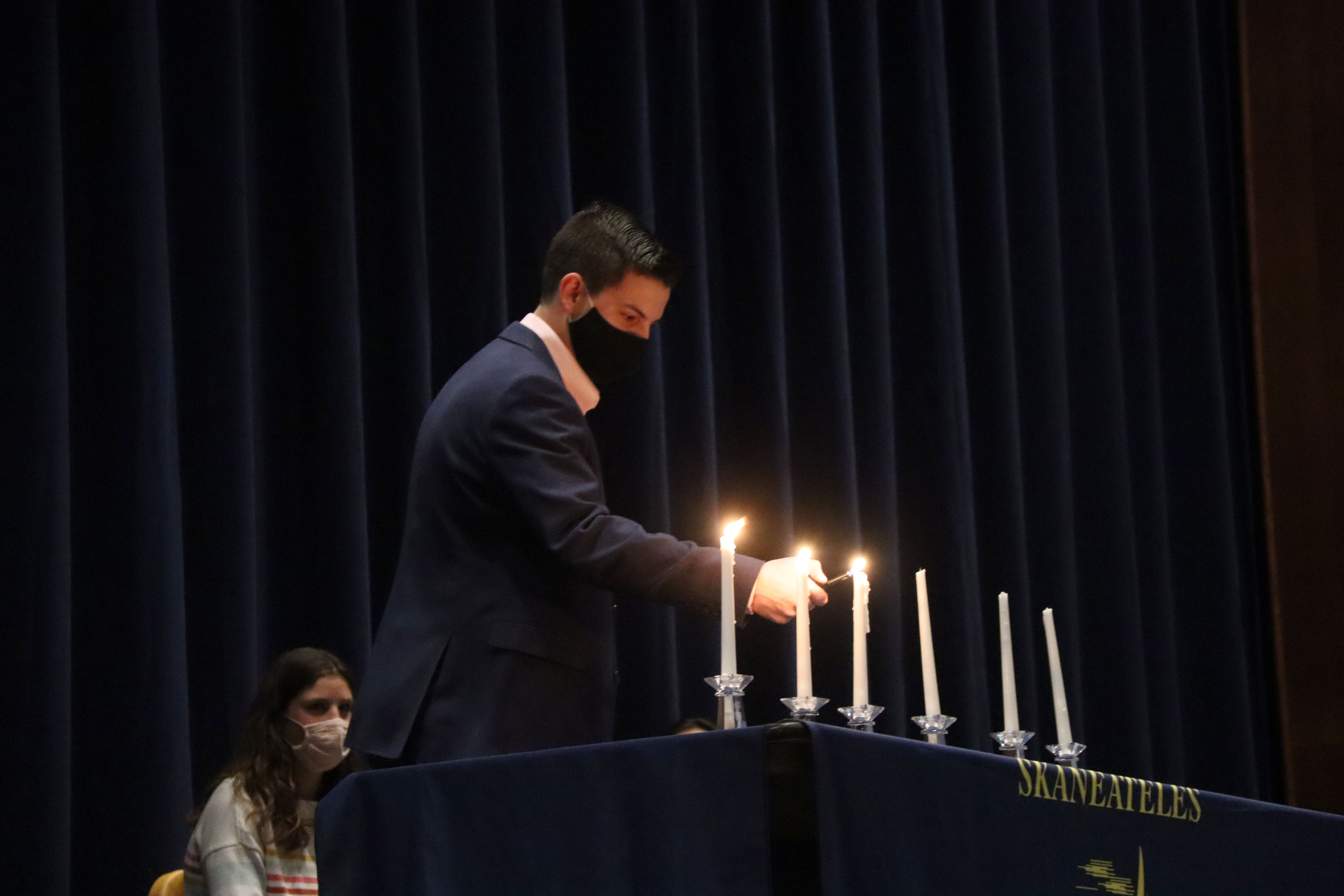 NJHS inductee lights candle at the induction ceremony