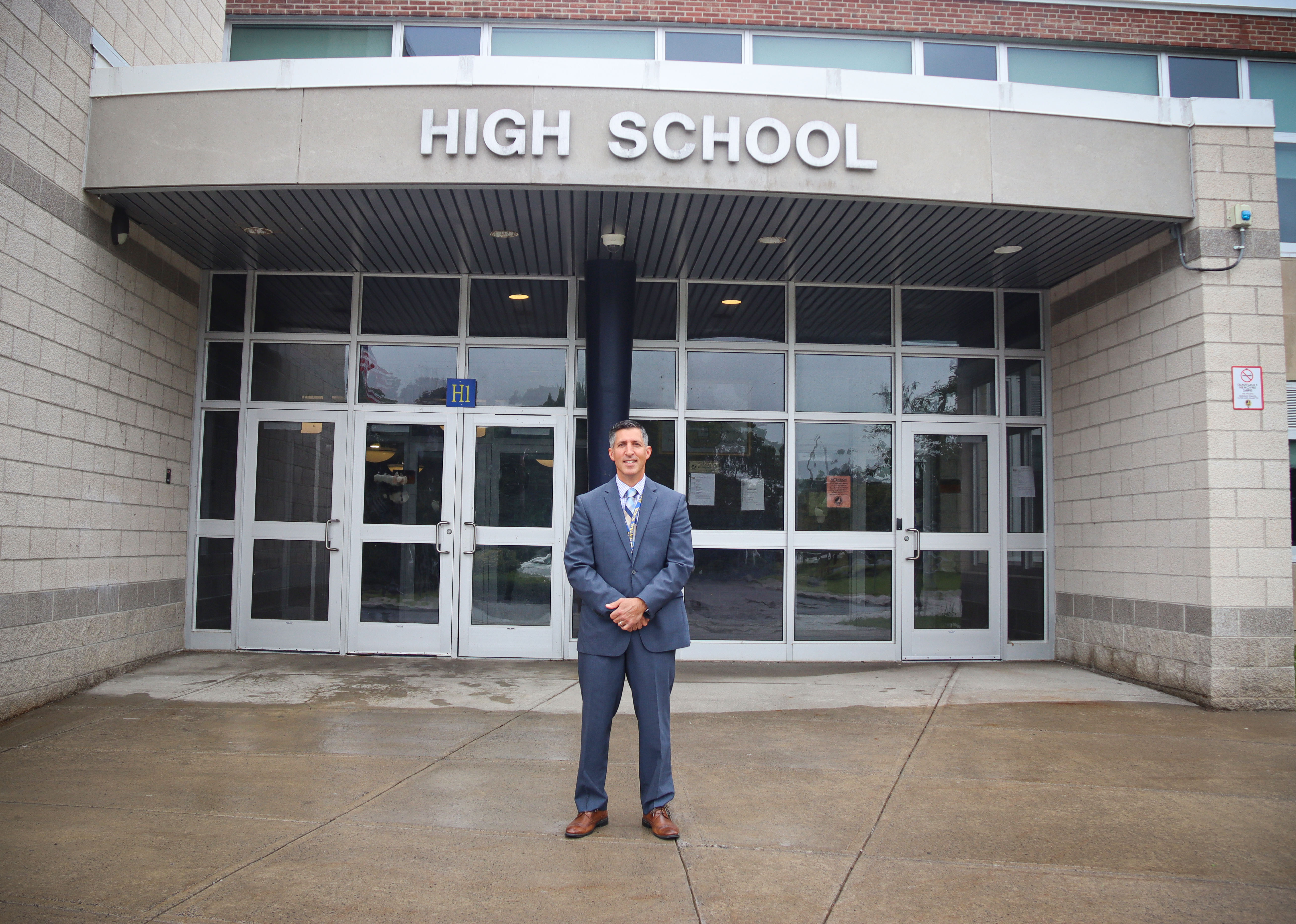 Michael Caraccio stands in front of High School building
