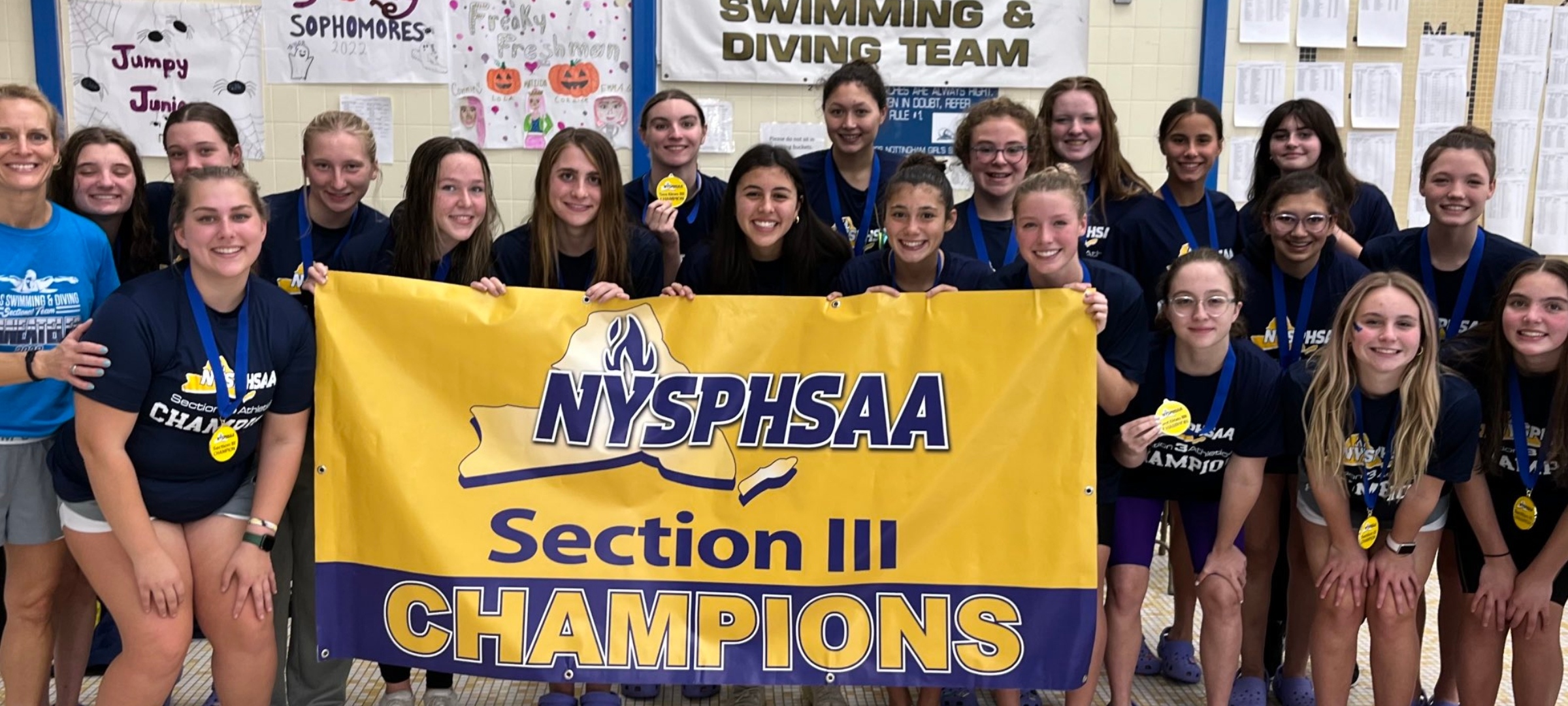 Swim Team holding Section III championship banner