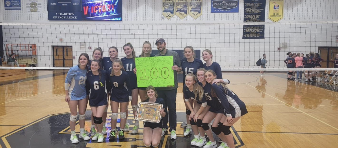 Coach Dan Mulroy celebrates his 100th victory after a volleyball win